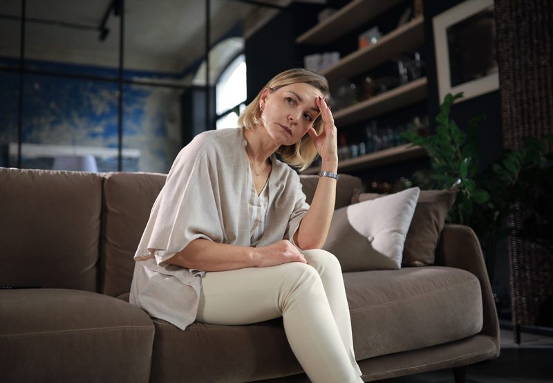 A-thoughtful-or-concerned-middle-aged-woman-sitting-on-a-bed A-thoughtful-or-concerned-middle-aged-woman-sitting-on-a-bed