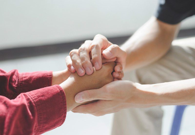 Close-up-of-a-man-holding-hands-with-a-psychologist