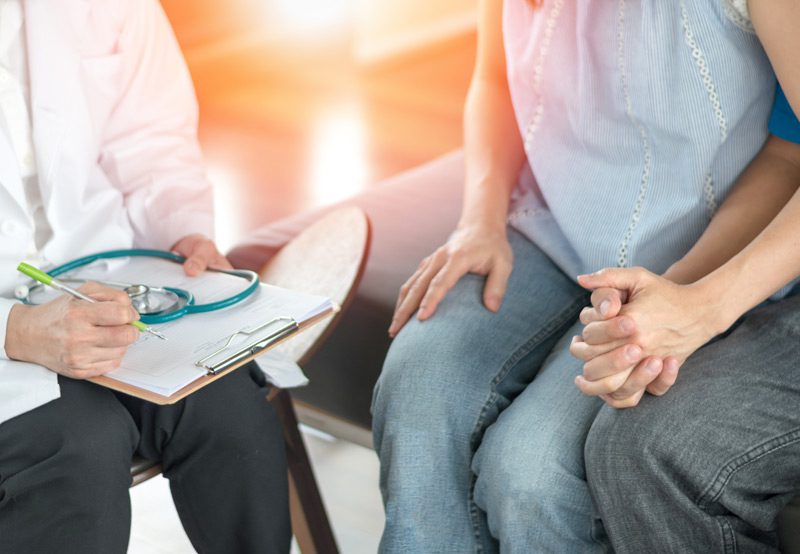 Couple-discussing-approach-of-retrieving-sperm-with-a-doctor Couple-discussing-approach-of-retrieving-sperm-with-a-doctor