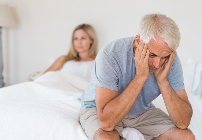Couple-sitting-on-opposite-sides-of-the-bed