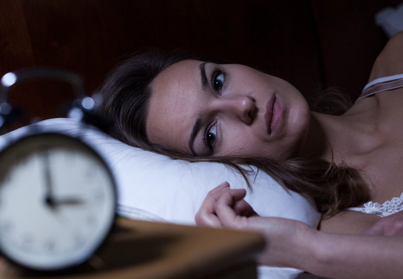 Woman-lying-awake-in-bed-illustrating-sleep-disturbances