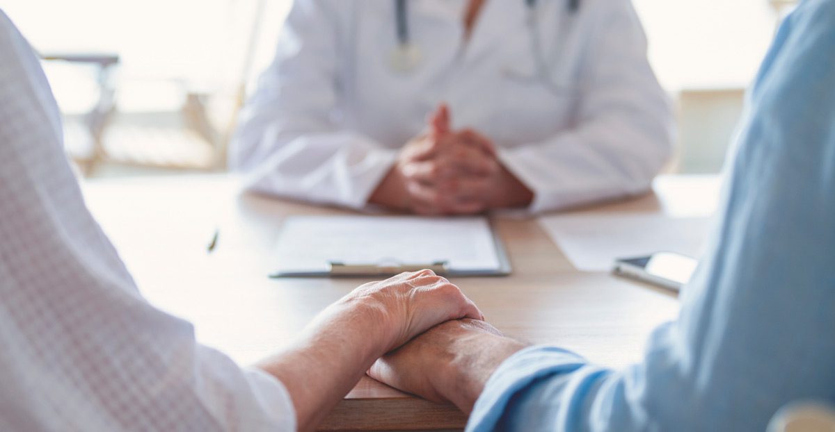 Mature couple holding hands at a doctor's office Mature couple holding hands at a doctor's office
