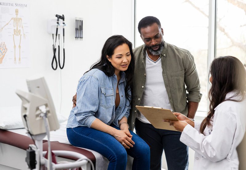 doctor talks with couple in office