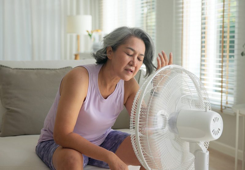 woman-sitting-in-front-of-fan